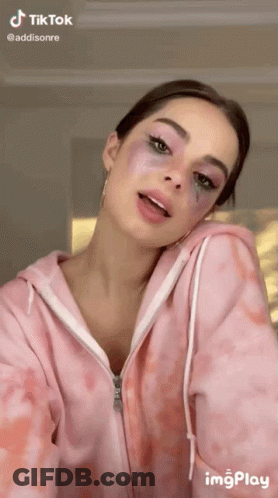 Woman In Pink Tie Dye Hoodie Looking At Camera GIF