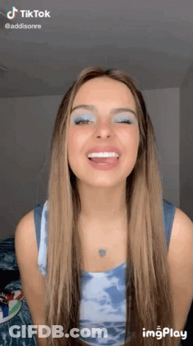 Woman In Pink Tie Dye Hoodie Looking At Camera GIF