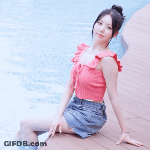 Woman In Pink Top And Denim Skirt By Pool GIF