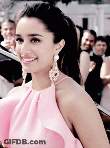 Woman In Pink Top And Earrings Smiling GIF