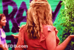 Woman In Pink Top By Green Wall Rev GIF
