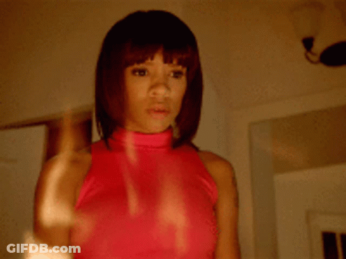 Woman In Pink Top Looking In Mirror GIF
