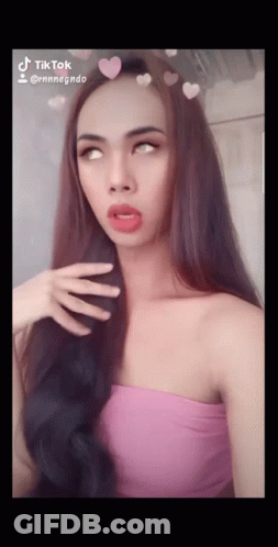 Woman In Pink Top With Hearts On Hair Says TikTok GIF