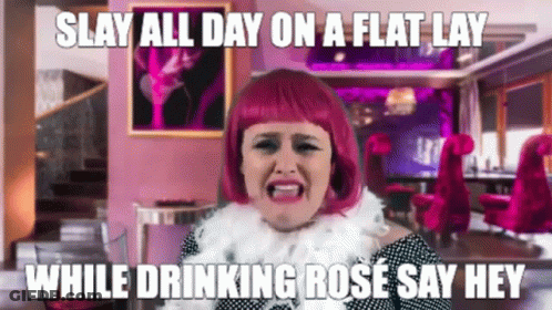 Woman In Pink Wig Making Funny Face Drinking Rose GIF