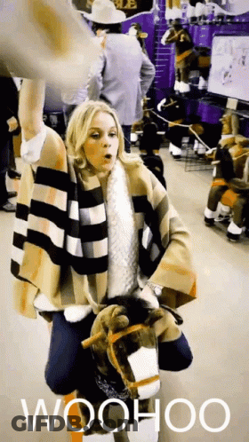 Woman In Plaid Coat Holding Stuffed Horse Saying Woohoo GIF
