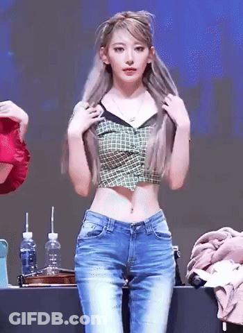 Woman In Plaid Crop Top And Jeans Standing At Table GIF
