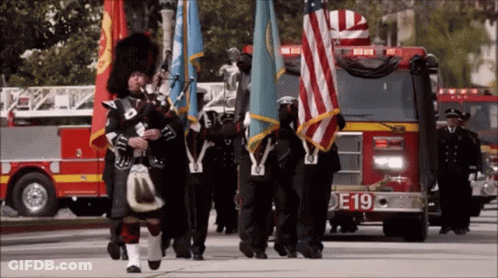 Woman In Plaid Jacket And Man Playing Bagpipes GIF