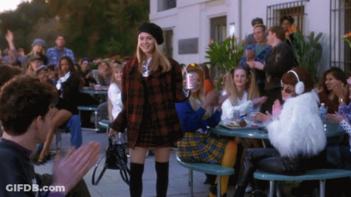 Woman In Plaid Jacket Before Crowd GIF
