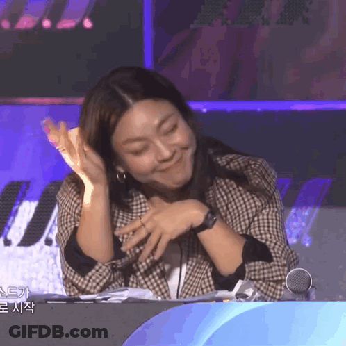 Woman In Plaid Jacket Funny Face At Microphone GIF