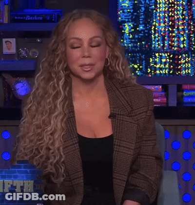 Woman In Plaid Jacket In Front Of Barbra Wall GIF
