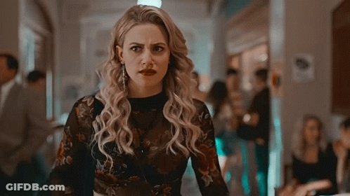 Woman In Plaid Shirt And Choker Standing Next To Another Woman GIF
