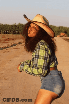 Woman In Plaid Shirt And Cowboy Hat On Dirt Road GIF