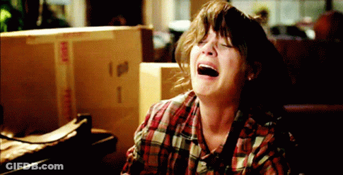 Woman In Plaid Shirt Crying In Front Of Fragile Box GIF