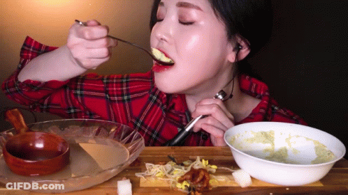 Woman In Plaid Shirt Eating Spoonful Of Food GIF