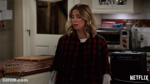 Woman In Plaid Shirt In Kitchen With Netflix Logo GIF