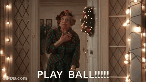 Woman In Plaid Shirt Says Play Ball By Christmas Lights GIF