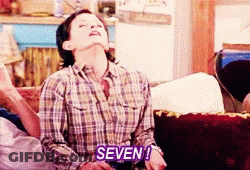 Woman In Plaid Shirt Says Purple Seven On Couch GIF