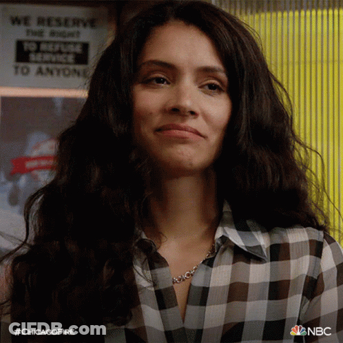 Woman In Plaid Shirt Smiling In Front Of Refuse Service Sign GIF