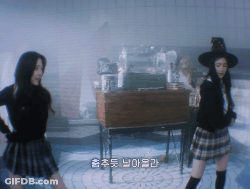 Woman In Plaid Skirt And Witch Hat Next To Another Woman GIF