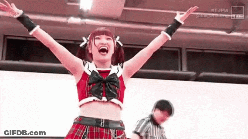 Woman In Plaid Skirt Raising Arms While Referee Watches GIF