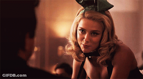 Woman In Playboy Bunny Outfit Looks At Man GIF
