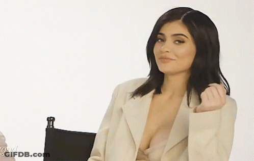 Woman In Plunging Neckline Sitting In Chair GIF