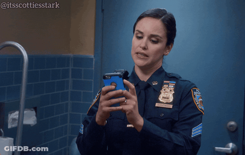 Woman In Police Uniform Holding Cell Phone Saying Still Porn GIF