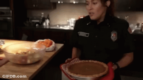 Woman In Police Uniform Holding Pumpkin Pie GIF