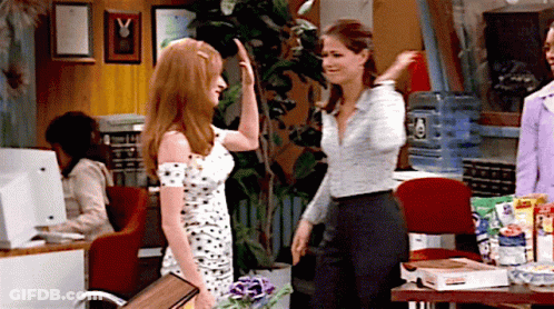 Woman In Polka Dot Dress High-Fives Another In Office GIF