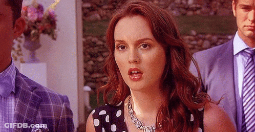 Woman In Polka Dot Dress Standing Before Man In Suit GIF