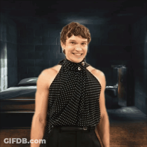 Woman In Polka Dot Top Smiling Behind Bars GIF