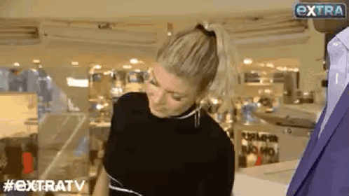 Woman In Ponytail Talking To Man In Suit In Store GIF