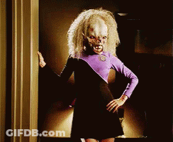 Woman In Purple And Black Dress In Doorway Hands On Hips GIF