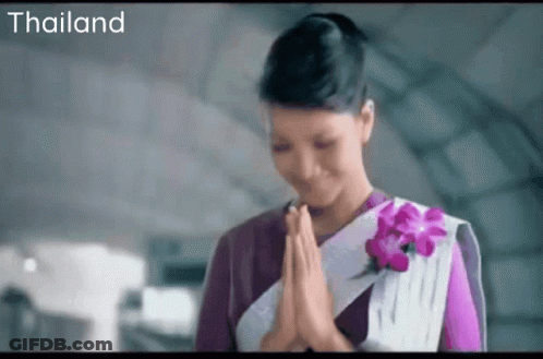 Woman In Purple And White Dress Praying By Thailand Sign GIF