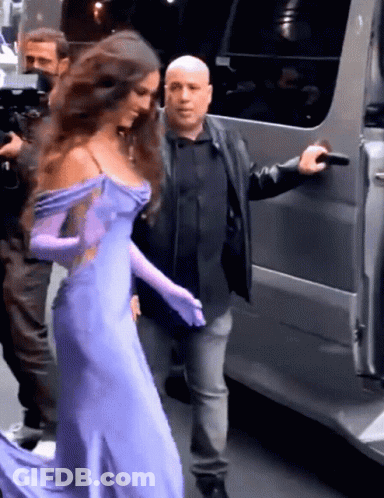 Woman In Purple Dress And Gloves Escorted GIF