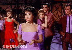 Woman In Purple Dress Before Red And Purple Dressed People GIF