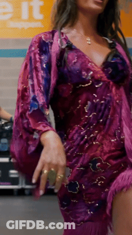 Woman In Purple Dress Dancing In Front Of Exit Sign GIF