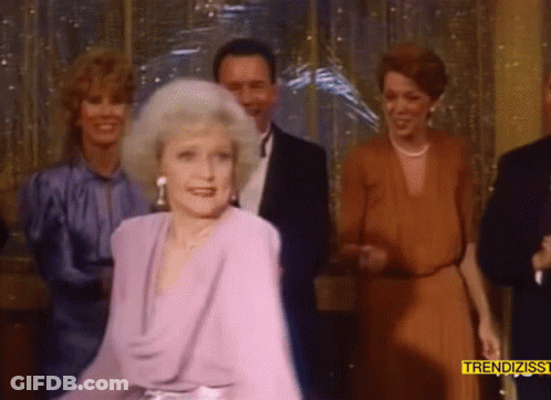 Woman In Purple Dress Dancing In Front Of Trendizss Sign GIF