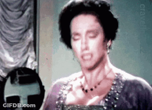 Woman In Purple Dress Looking In Mirror GIF