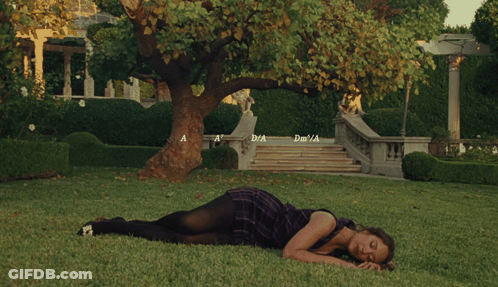 Woman In Purple Dress Lying On Grass By Tree Stairs GIF