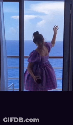 Woman In Purple Dress Overlooking Ocean GIF