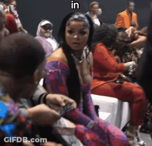 Woman In Purple Dress Sitting In Crowd With Word In GIF