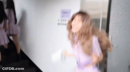 Woman In Purple Dress Standing In Front Of Door GIF