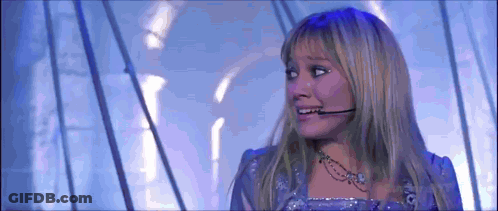 Woman In Purple Dress With Microphone On Ear GIF