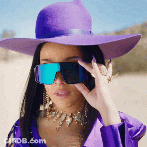 Woman In Purple Hat And Sunglasses Looking At Camera GIF