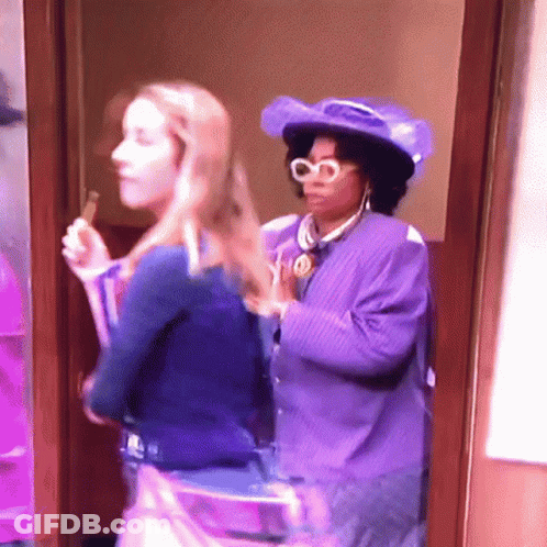 Woman In Purple Hat Next To Woman In Blue Shirt GIF