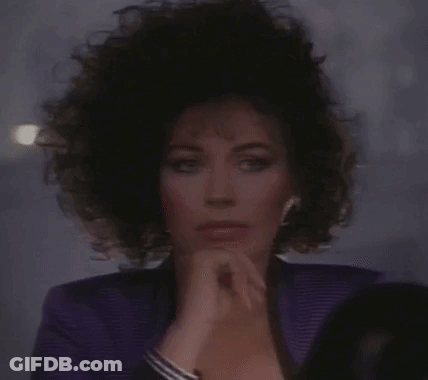 Woman In Purple Jacket Looking In Mirror GIF