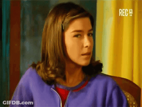 Woman In Purple Jacket Sitting Looking At Camera GIF