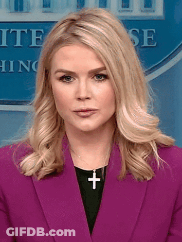 Woman In Purple Jacket With Cross Necklace GIF