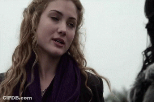 Woman In Purple Scarf And Black Jacket Talking To Man GIF